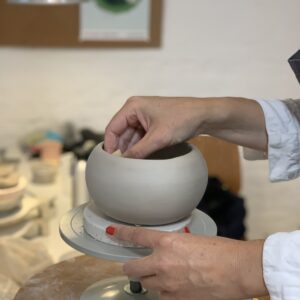 hænder laver en krukke i keramik