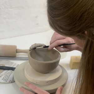 kvinde lærer pølseteknik på keramik workshop